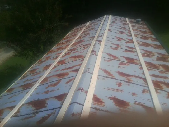 Rusted metal roof panels with new wood purlins before replacement — Storm Damage Roof Repair in Reedsport by Roofing Brothers