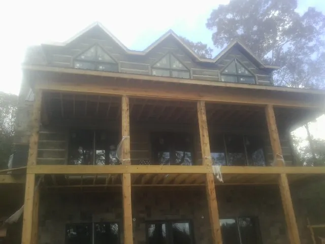Dormers and porch framing on a large log home under construction — Roof Coating work by our crew in Reedsport