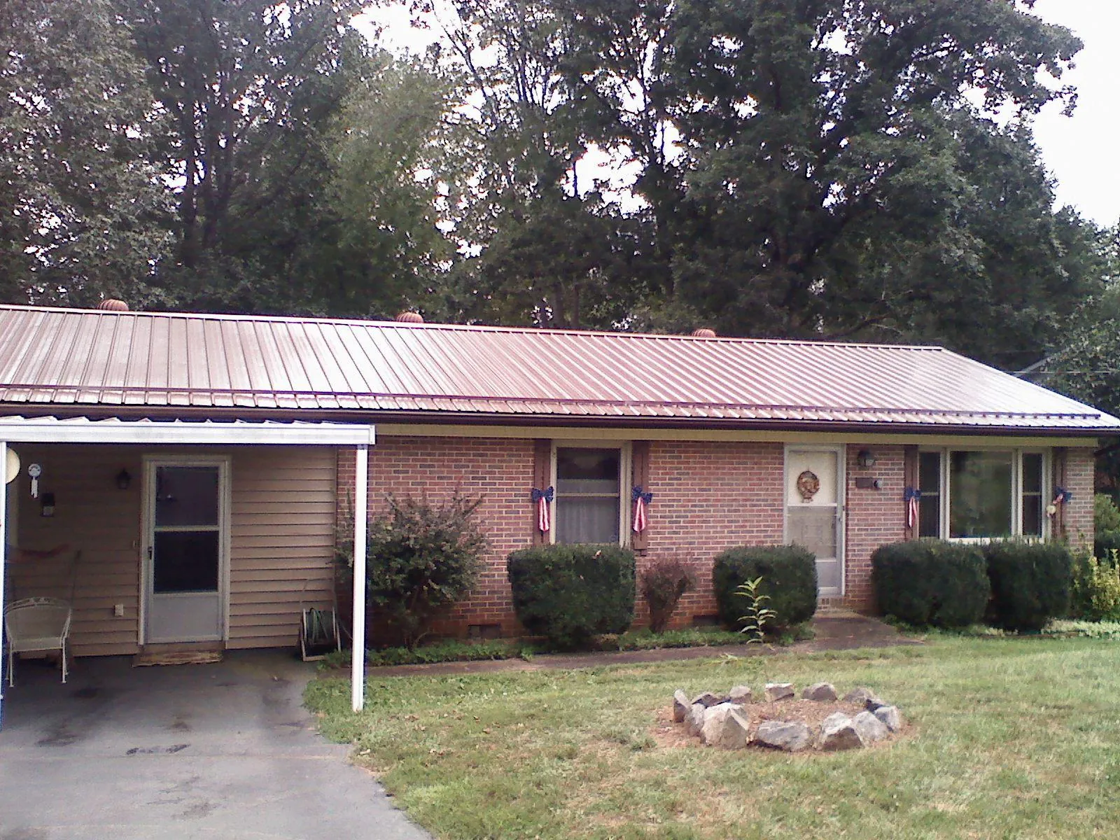 Bronze metal roof and carport on a brick ranch home — Roof Repair work by our crew in Reedsport
